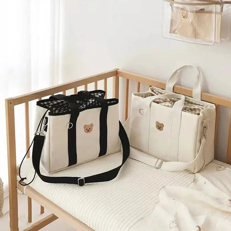 Deux sacs à langer compacts NappyPack posés dans une chambre de bébé - Bébé Lova