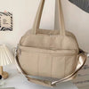 Sac à langer sport taupe imperméable porté avec sa sangle bandoulière - Bébé Lova