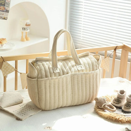 Sac à langer beige posé dans une chambre de bébé au style naturel et chaleureux - Bébé Lova