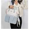 Femme tenant le sac à langer bleu et crème à la main - Bébé Lova
