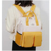 Femme portant le sac à langer jaune et blanc sur le dos - Bébé Lova
