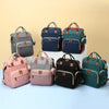 Sac à langer de voyage présenté dans ses différents coloris : gris, marine, rose, noir, vert et bicolore - Bébé Lova