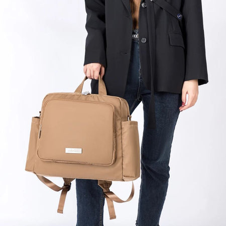 Sac à langer imperméable premium camel tenu à la main pour illustrer son format pratique - Bébé Lova