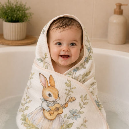 Bébé enveloppé dans une serviette en gaze de coton motif lapin musicien au sortir du bain - Bébé Lova