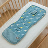 Matelas de poussette à motif dinosaures bleu posé dans un lit à barreaux - Bébé Lova
