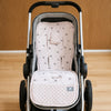 Matelas de poussette à motif pissenlits rose installé dans une poussette vue de face - Bébé Lova