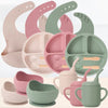 Coloris disponibles du set de vaisselle en silicone : bavoirs, assiettes, bols et tasses à paille en beige, rose et vert - Bébé Lova