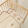 Tapis à langer matelassés disposés dans un berceau au cœur d'une chambre d'enfant - Bébé Lova