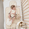 Bébé endormi sur le tapis à langer matelassé dans son berceau avec peluche et panier - Bébé Lova