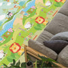 Tapis de jeu éducatif vert à motifs animaux et chiffres déployé dans un salon près d'un canapé en tissu gris - Bébé Lova