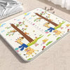 Tapis de jeu éducatif pliable motif arbre et animaux avec toise, posé dans une chambre - Bébé Lova