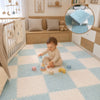 Bébé jouant sur un tapis puzzle CozyMat bleu clair et écru dans une chambre, avec aperçu des dalles emboîtables - Bébé Lova