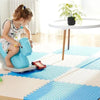 Enfant jouant sur un tapis puzzle EVA bleu et blanc avec cheval à bascule dans une pièce lumineuse - Bébé Lova