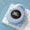 Thermomètre de bain bébé bleu posé sur un carrelage au bord de l'eau affichant 36°C - Bébé Lova