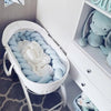 Nouveau-né installé dans un berceau avec tour de lit tressé bleu pastel - Bébé Lova