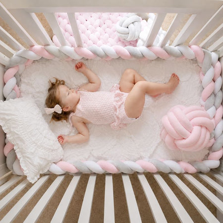 Tour de lit tressé épais rose gris et blanc installé dans un lit bébé - Bébé Lova