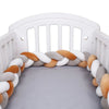 Tour de lit tressé artisanal gris, caramel et blanc installé dans un lit bébé - Bébé Lova