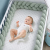Bébé allongé dans un lit avec tour de lit tressé vert sauge pour une protection douce et confortable - Bébé Lova
