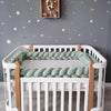Tour de lit tressé vert sauge installé sur tout le contour d’un lit bébé à barreaux - Bébé Lova