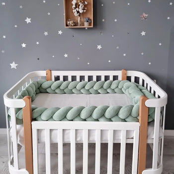 Tour de lit tressé vert sauge installé sur tout le contour d’un lit bébé à barreaux - Bébé Lova