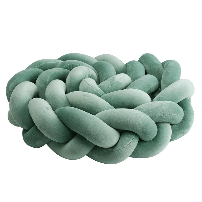 Tour de lit tressé vert sauge présenté en version coussin de protection noué - Bébé Lova