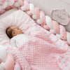 Bébé endormi avec tour de lit tressé rose et blanc à motifs dans un lit bébé cosy - Bébé Lova