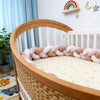 Tour de lit tressé rose et blanc installé dans un berceau bébé en bois - Bébé Lova