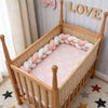 Tour de lit tressé rose et blanc à motifs dans un lit bébé avec décoration LOVE - Bébé Lova
