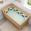 Tour de lit tressé vert et blanc avec motifs jungle dans un lit bébé décoré - Bébé Lova