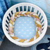Tour de lit tressé jaune pastel et rose dans un berceau rond bébé - Bébé Lova