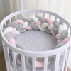 Tresse de lit coloris gris, rose et blanc installée dans un lit rond - Bébé Lova