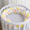 Tresse de lit coloris jaune, rose et blanc installée dans un lit rond - Bébé Lova