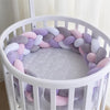 Tresse de lit coloris violet, gris, rose et blanc dans un lit rond - Bébé Lova