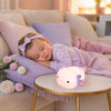 Bébé endormi sur un canapé avec la veilleuse axolotl allumée sur une table - Bébé Lova