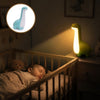 Bébé endormi dans un berceau avec la veilleuse dinosaure verte allumée sur la commode et un encart du modèle bleu - Bébé Lova