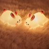 Duo de veilleuses lapin RabbitLight allumées sur tapis fourrure ambiance cocooning - Bébé Lova