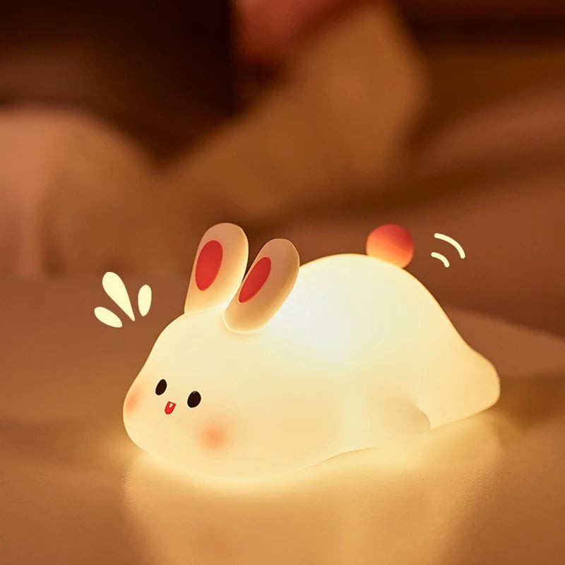 Veilleuse lapin RabbitLight posée près du lit de bébé en lumière tamisée chaleureuse - Bébé Lova