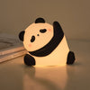 Veilleuse panda LED tactile PandaLight posée sur une table de chevet avec lumière douce - Bébé Lova